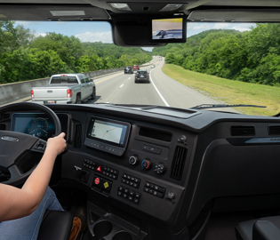Freightliner truck dashboard and windshield view showing highway driving perspective and digital controls